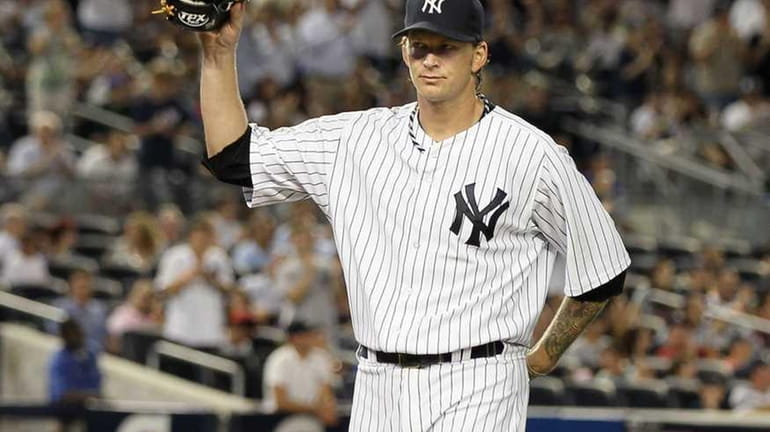 A.J. Burnett #34 of the New York Yankees salutes the...