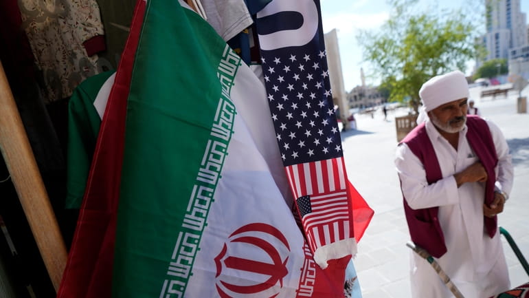 An Iranian flag and a scarf depicting U.S. flag are...