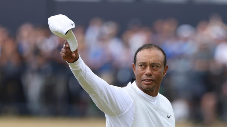 Tiger Woods of the US gestures to the crowd at...