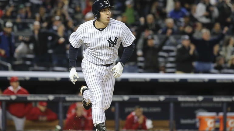 Yankees first baseman Mark Teixeira watches his solo home run...