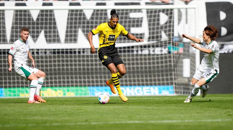Dortmund's Sebastien Haller, center, controls the ball during the German...