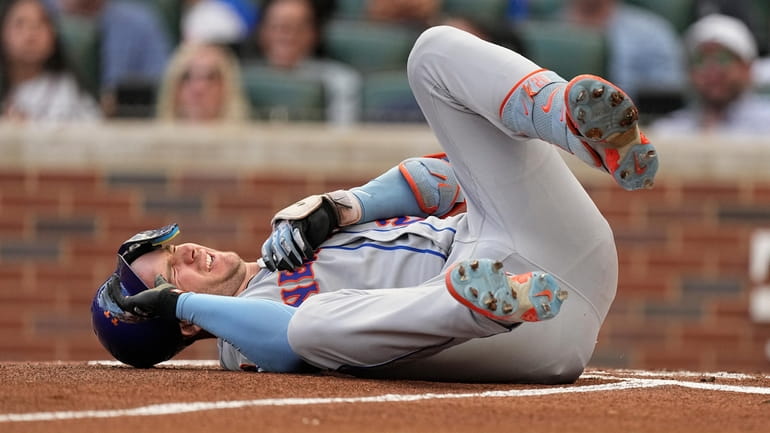 Mets first baseman Pete Alonso reacts after being hit by...