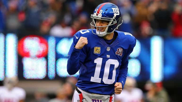 Eli Manning celebrates after throwing a touchdown in the first...