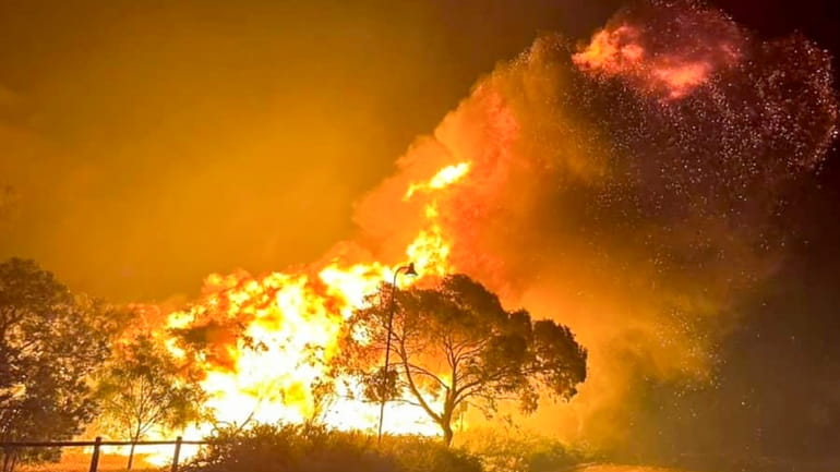 A fire rages in bushland near the West Australian city...