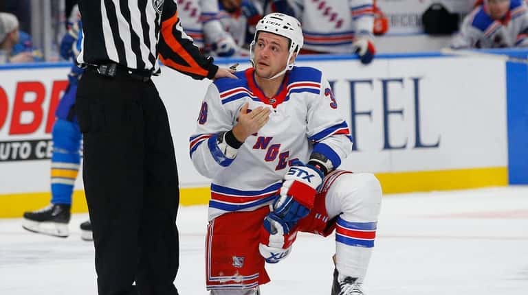 Referee Chris Lee looks in on New York Rangers' Micheal...