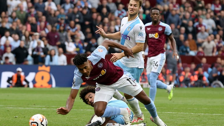 Aston Villa's Ollie Watkins, front, is fouled by Crystal Palace's...