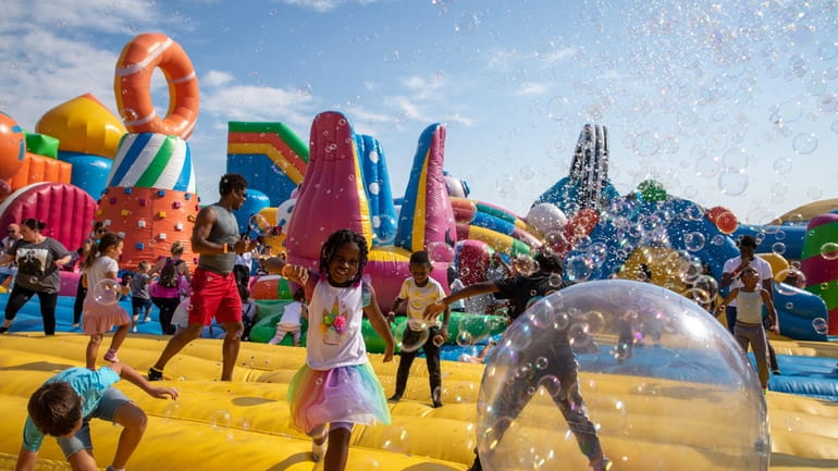 Kids jump around inside the "World's Biggest Bounce House" at...