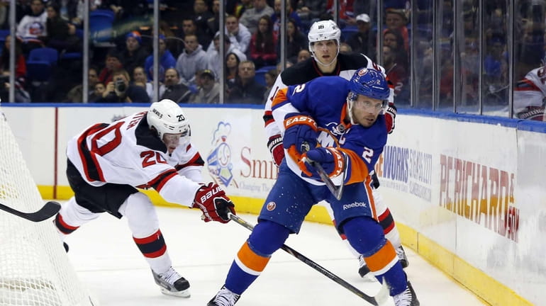 Mark Streit of the Islanders clears the puck from Ryan...