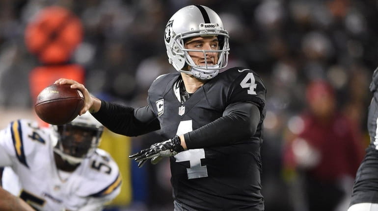 Derek Carr #4 of the Oakland Raiders drops back to...