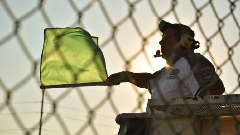A flagman waves the green flag at Riverhead Raceway. (July...