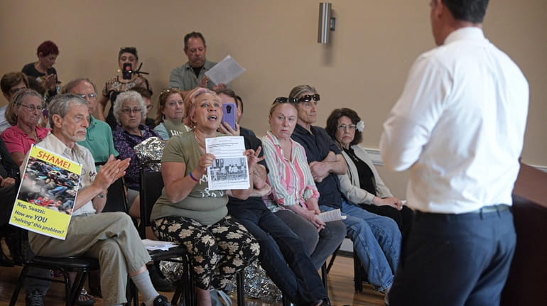 Immigration activists speak to Rep. Thomas Suozzi during a town...