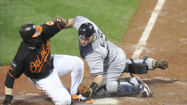 Russell Martin of the New York Yankees tags out Vladimir...