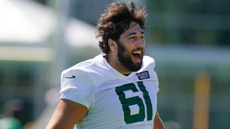 Jets offensive lineman Max Mitchell calls out to fans before drills...