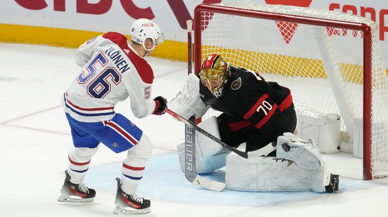 Ottawa Senators goaltender Joonas Korpisalo, right, makes a save against...