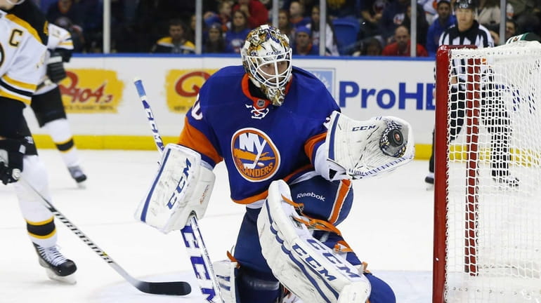 Islanders goaltender Kevin Poulin makes a second-period glove save against...
