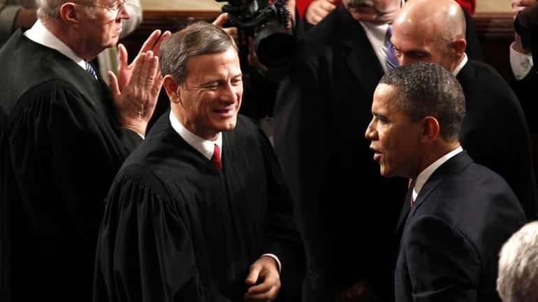 Supreme Court Chief Justice John Roberts greets President Barack Obama...