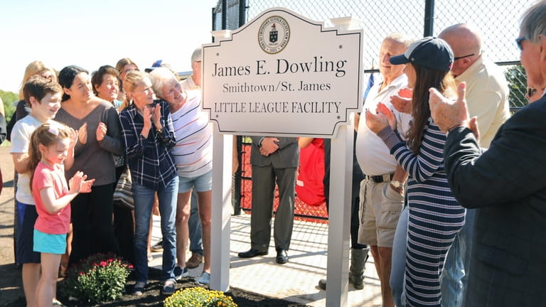 Family members of James E. Dowling unveil a new sign during...