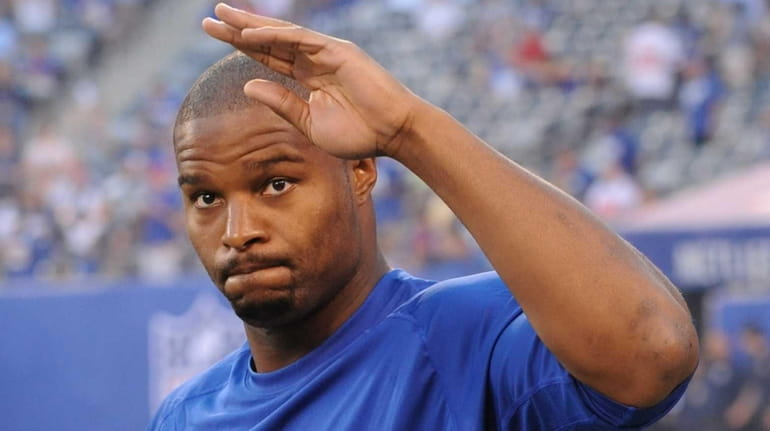 New York Giants defensive end Osi Umenyiora waves to fans...