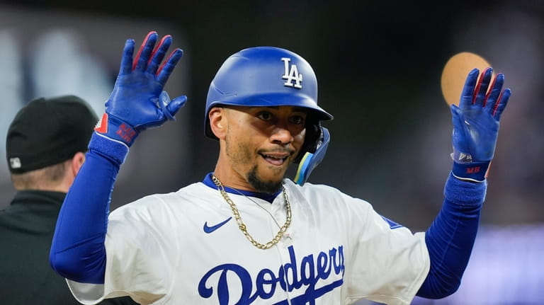 Los Angeles Dodgers' Mookie Betts celebrates after hitting a triple...