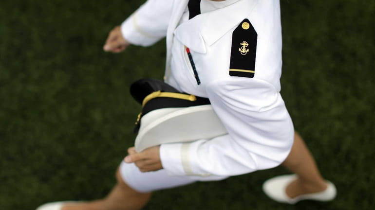A graduating U.S. Naval Academy Midshipman marches into the Academy's...