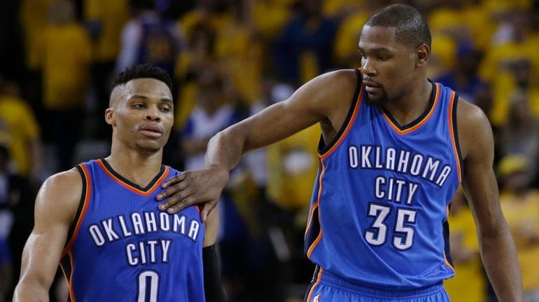 Oklahoma City Thunder's Kevin Durant, right, pats teammate Russell Westbrook...