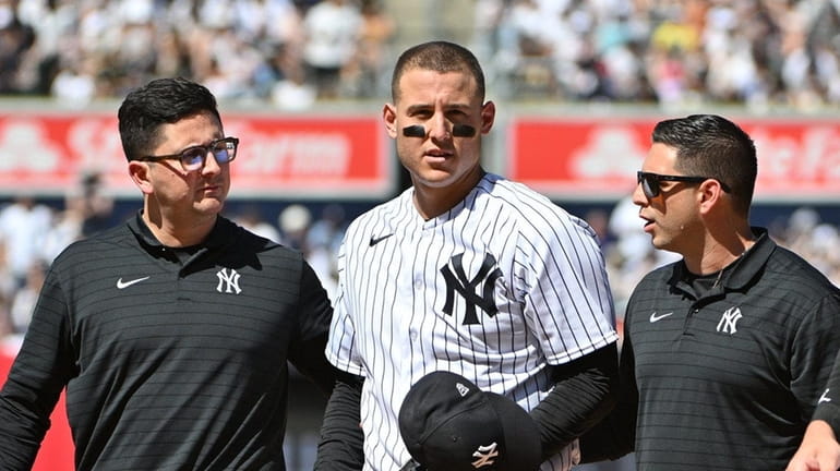 Yankees' Anthony Rizzo is assisted off the field during the...