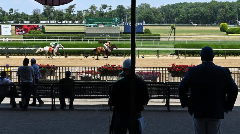 Employees watch a race during the Belmont Stakes at Belmont...