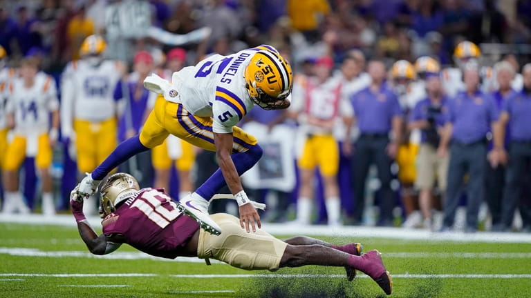 LSU quarterback Jayden Daniels (5) is upended by Florida State...