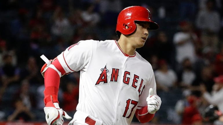The Angels' Shohei Ohtani rounds the bases after his home run...