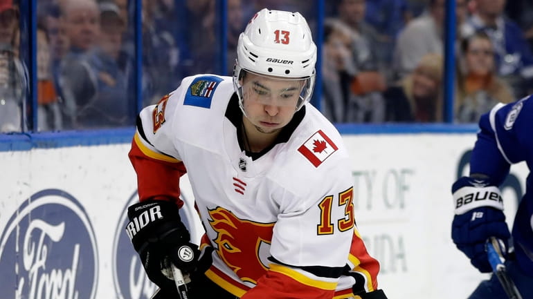 Flames left wing Johnny Gaudreau carries the puck past Lightning left...