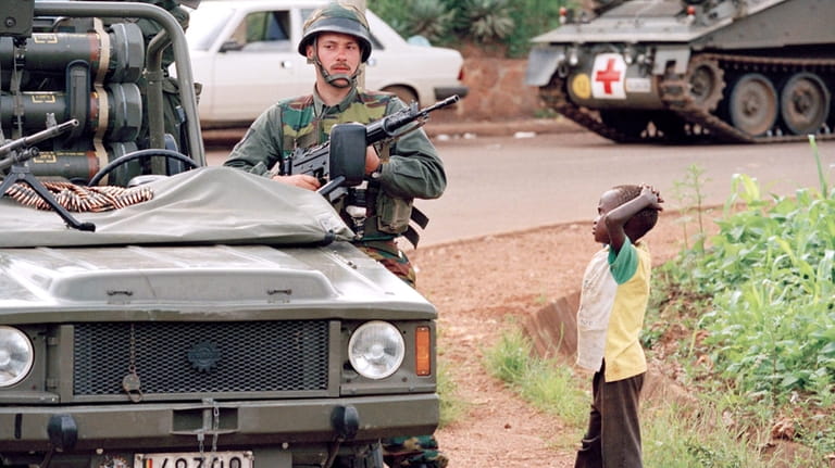 A young Rwanda boy looks at a Belgian soldier in...