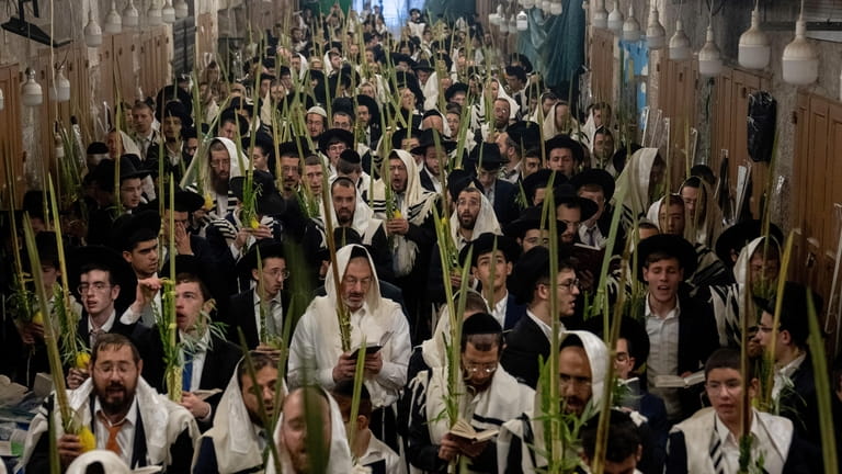 Jewish worshippers pray during the weeklong Jewish holiday of Sukkot,...
