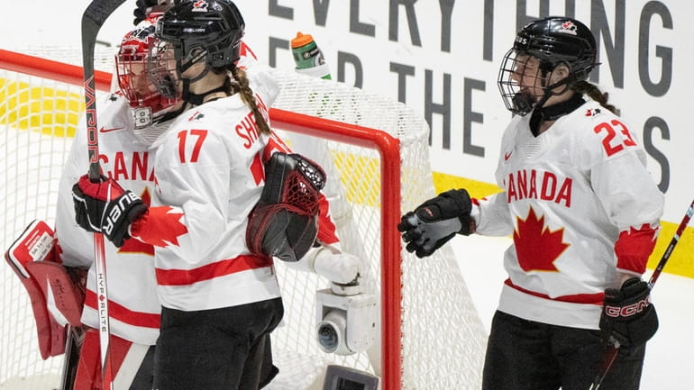 Canada goaltender Emerance Maschmeyer, left, celebrates with teammates Ella Shelton...