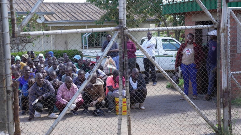 Prisoners kneel at the entrance of Chikurubi Maximum prison before...