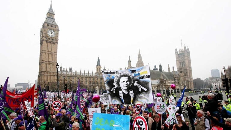 Demonstrators march past Parliament Square in London to protest against...