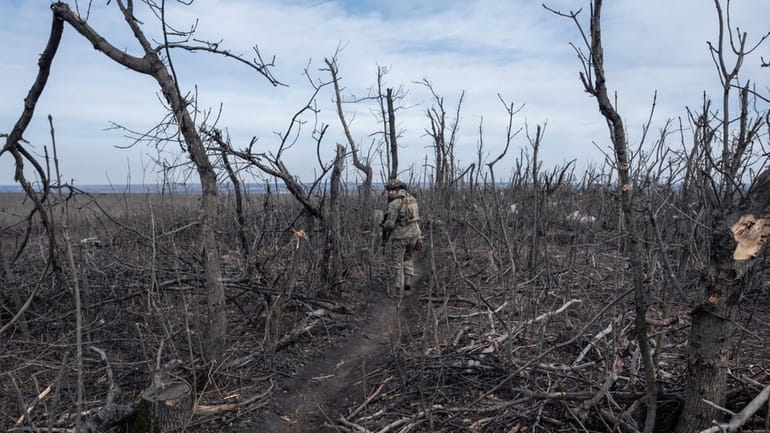 A Ukrainian soldier walks in position on the front-line near...
