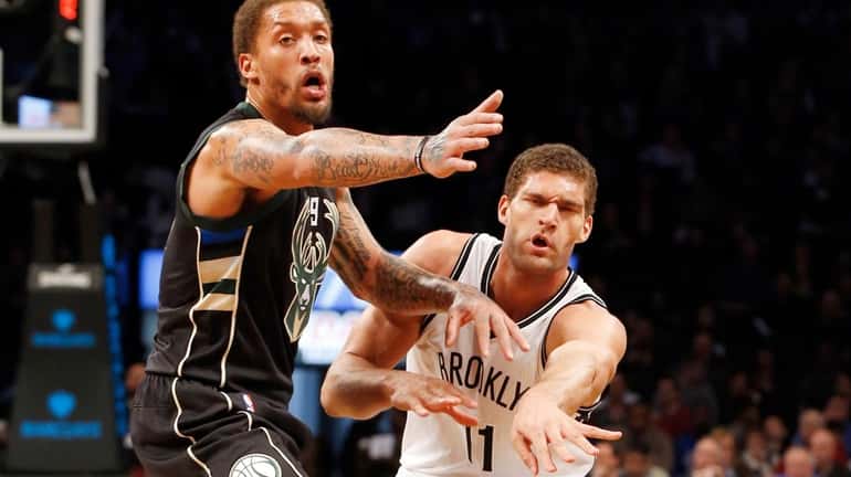 Brook Lopez #11 of the Brooklyn Nets passes the ball...