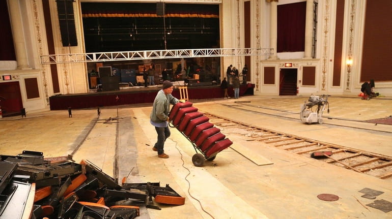 Workers carry away old seats at the Patchogue Theatre for...