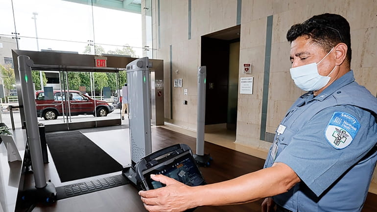 A Northwell Health security officer monitors a new metal detector at...