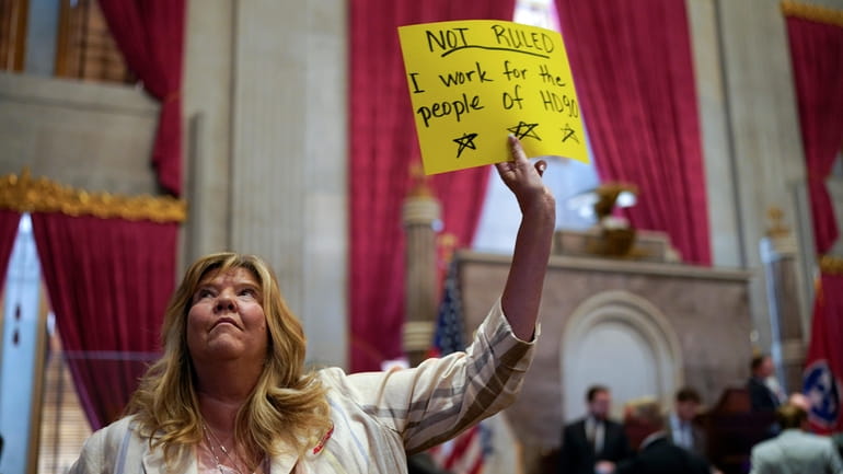 Rep. Gloria Johnson, D-Knoxville, holds a sign on the House...