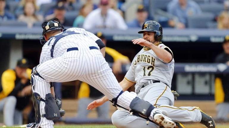 Gaby Sanchez of the Pittsburgh Pirates is tagged out at...