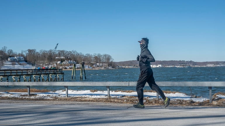 A man jogs along Cove Neck Road, the only main...