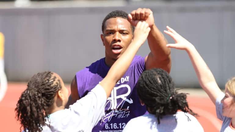 Ray Rice celebrates with participants after finishing jumping jacks during...