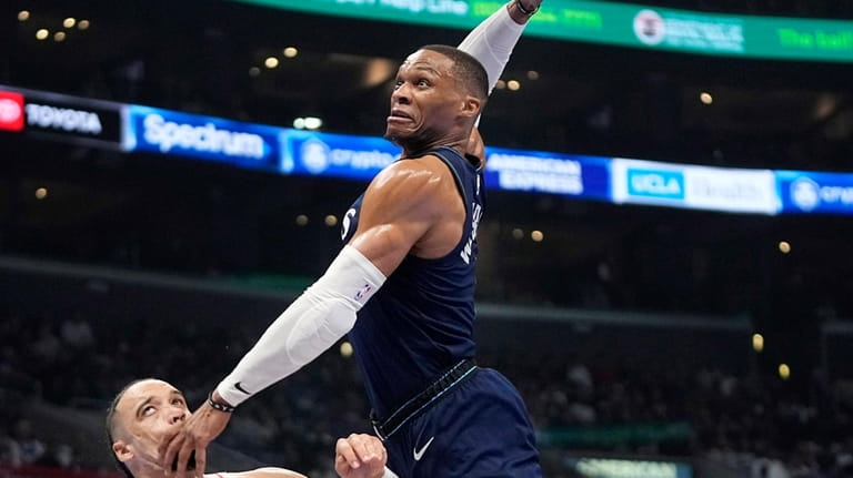 Los Angeles Clippers guard Russell Westbrook, center, attempts a dunk...