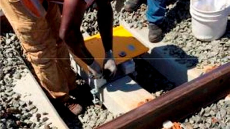 Workers install a radio transponder for the positive train control...