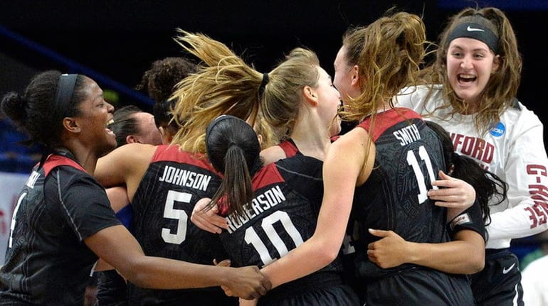 Members of the Stanford women's team celebrate after defeating Notre...