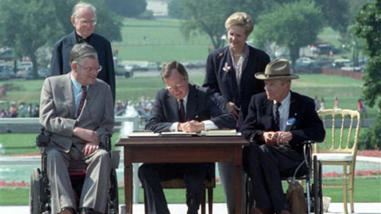 President George H. W. Bush signs the Americans with Disabilities...