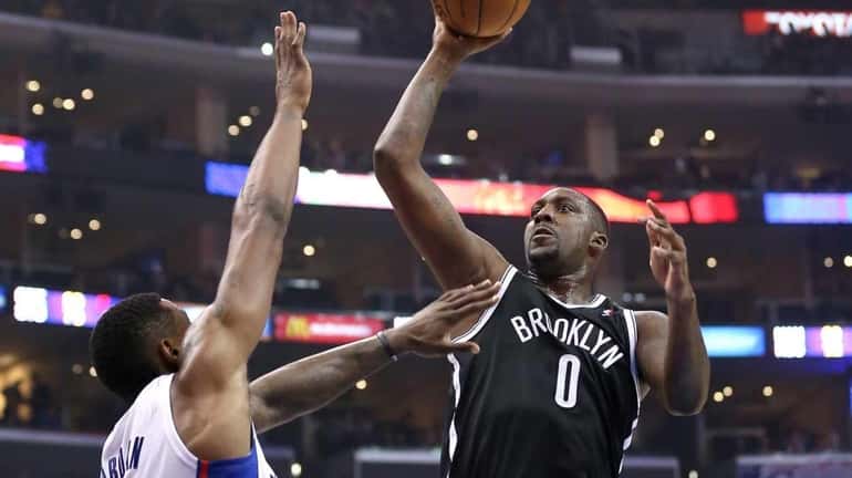 Andray Blatche of the Nets shoots over DeAndre Jordan of...