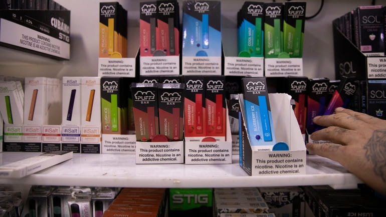 This January 2020 photo shows various brands and flavors of disposable vape...