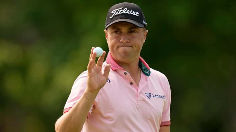 Justin Thomas waves after making a putt on the 14th...